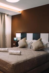a bedroom with a large bed with pillows on it at Takuá Hotel Serrano in La Punta +13 photos