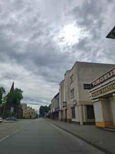 an empty street in a town with a building at Žemaičių g apartamentai in Kretinga
