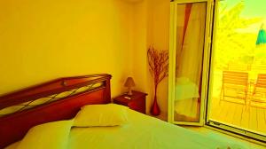 ein Schlafzimmer mit Bett und Glastür zum Balkon in der Unterkunft LECÉLESTE in Lithakia