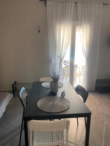 a dining table and chairs with a table and a window at Tsatsoni Studios in Velika