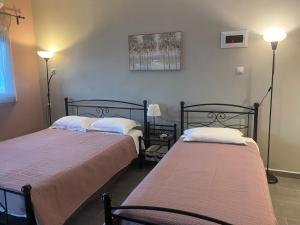 two beds sitting in a room with two lamps at Tsatsoni Studios in Velika