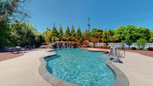 a swimming pool with a waterfall in a backyard at Coastal Estate in Cape May