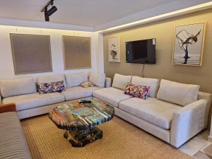 a living room with a couch and a tv at La villa de mamie in Dar Ito Lahssene