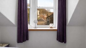 a window with purple curtains and a wine glass at Bute Seaview in Rothesay +3 photos