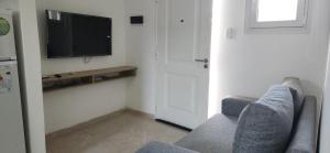 a living room with a couch and a flat screen tv at Añelo Garden Inn in Añelo