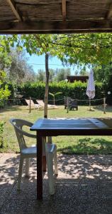 a picnic table with a chair and an umbrella at Casa Adua in Donoratico