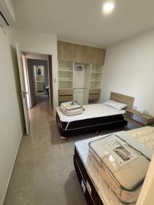 a room with two beds and a hallway with shelves at Añelo Garden Inn in Añelo