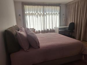 a bedroom with a bed with pillows and a window at La villa de mamie in Dar Ito Lahssene +20 photos