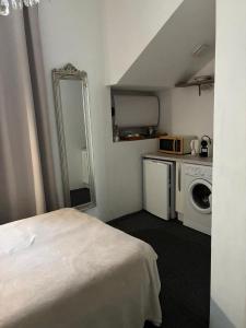 a room with a bed and a washing machine and a mirror at Studio 11T Sleeps 2 with WiFi in Beausoleil