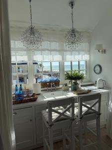 a kitchen with a sink and a counter with windows at Villa Celine in Mielno