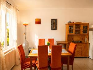 a dining room with a wooden table and orange chairs at Diófa Apartman Balatonederics in Balatonederics +11 photos
