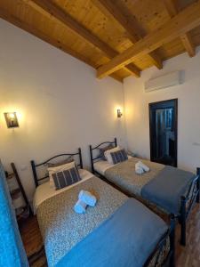 two twin beds in a room with wooden ceilings at Orange3 Hostel in Lagos