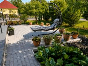 a garden with a chair and potted plants at Diófa Apartman Balatonederics in Balatonederics