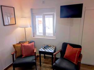 a room with two chairs and a table and a window at Entre Muralhas - Cozy Apartment Elvas I in Elvas