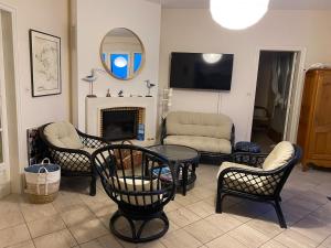 a living room with chairs and a table and a tv at Ty avel in Crozon
