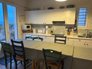 a kitchen with a table and chairs and a counter top at Ty avel in Crozon