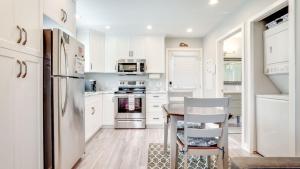 a kitchen with white cabinets and a table and chairs at Chims Cabins - Port Alberni in Port Alberni