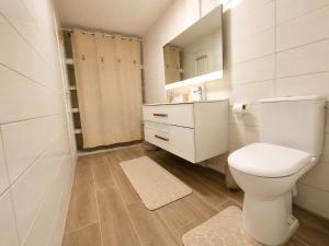 a white bathroom with a toilet and a mirror at Villa Coralys - Plage - Cozy in Schœlcher