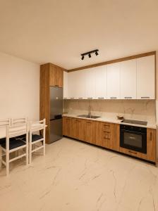 a kitchen with white cabinets and a counter top at Kron apartment in Shëngjin