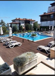 a swimming pool with lounge chairs and a bunch ofitures at Sea view and more in Bŭnzareto