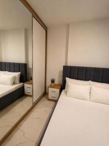 a bedroom with two beds and a large mirror at Kron apartment in Shëngjin +8 photos