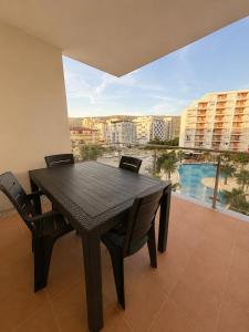 a black table and chairs in a room with a large window at Kron apartment in Shëngjin
