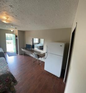 a living room with a white refrigerator and a desk at Pine Creek Motel in Waskatenau