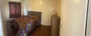 a small bedroom with a bed and a window at Pine Creek Motel in Waskatenau