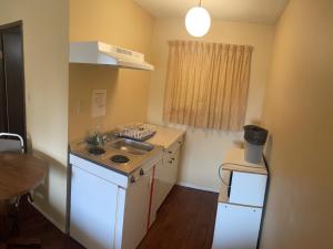 a small kitchen with a sink and a stove at Pine Creek Motel in Waskatenau