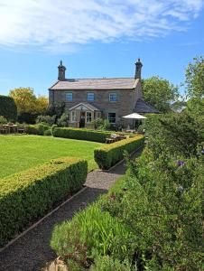 a large brick house with bushes in front of it at Lucker Mill House in Lucker