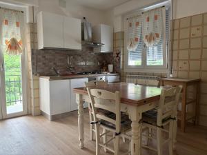 a kitchen with a wooden table and chairs at Patty House in Colico