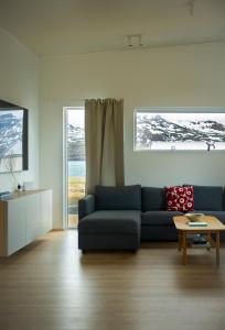 a living room with a blue couch and a table at Sigurstapi, Borgarfjörður Eystri in Borgarfjörður Eystri