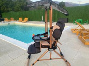 a chair under an umbrella next to a pool at Dutaka Boutique Villa with Pool in Polje Ostružnica