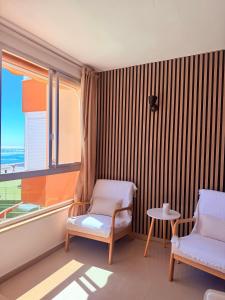 a room with two chairs and a table and a window at Brisa Mediterránea Torrox Costa in Torrox Costa