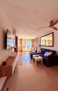 a living room with a blue couch and a table at Brisa Mediterránea Torrox Costa in Torrox Costa