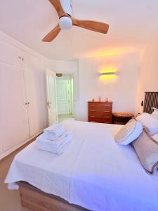 a bedroom with a white bed with a ceiling fan at Brisa Mediterránea Torrox Costa in Torrox Costa +10 photos