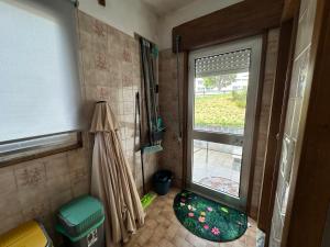 a bathroom with a window and a door with a rug at Cantinho da Mariana in Moledo +135 photos