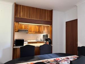 a kitchen with wooden cabinets and a counter top at Cantinho da Mariana in Moledo