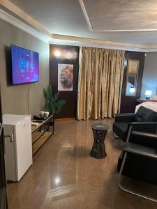 a living room with a couch and a table and a tv at Silver Gates BnB in Mbabane +23 photos