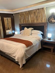 a bedroom with a large bed and a clock on the wall at Silver Gates BnB in Mbabane