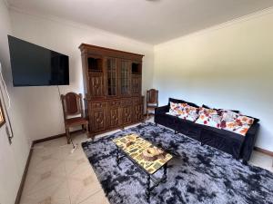 a living room with a couch and a flat screen tv at Cantinho da Mariana in Moledo