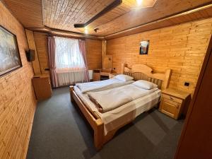 a bedroom with a large bed in a wooden room at Smerekova Hata in Yablunytsya