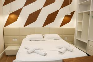 a bedroom with a bed with slippers on it at Airen Hotel Velipoje in Velipojë