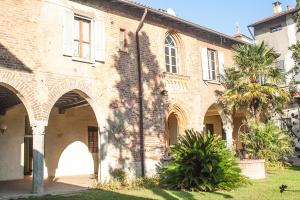 an old brick building with a palm tree in front of it at Casa Berra in Milan