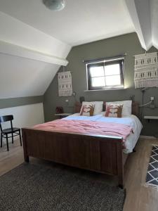 a bedroom with a large bed and a window at Atelier Onder de Notenboom in Appeltern
