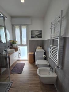 a bathroom with two toilets and a sink at In Blu Santo Ospedale in Padova