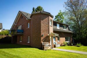 a large brick house with a grass yard at Reload Apartments - FeWo1 im Remmeker Feld in Bad Arolsen