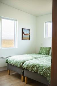 a bed in a white room with a window at Sigurstapi, Borgarfjörður Eystri in Borgarfjörður Eystri