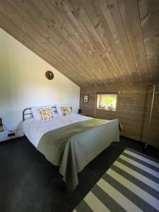a large bed in a room with a wooden ceiling at Atelier Onder de Notenboom in Appeltern