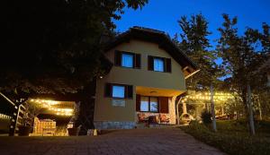 a house with lights on the side of it at night at Apartment ZARJA in Dobrnič